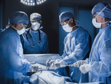 Group of surgeon at work in operating theatre. Medical team performing operation.
