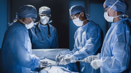 Group of surgeon at work in operating theatre. Medical team performing operation.